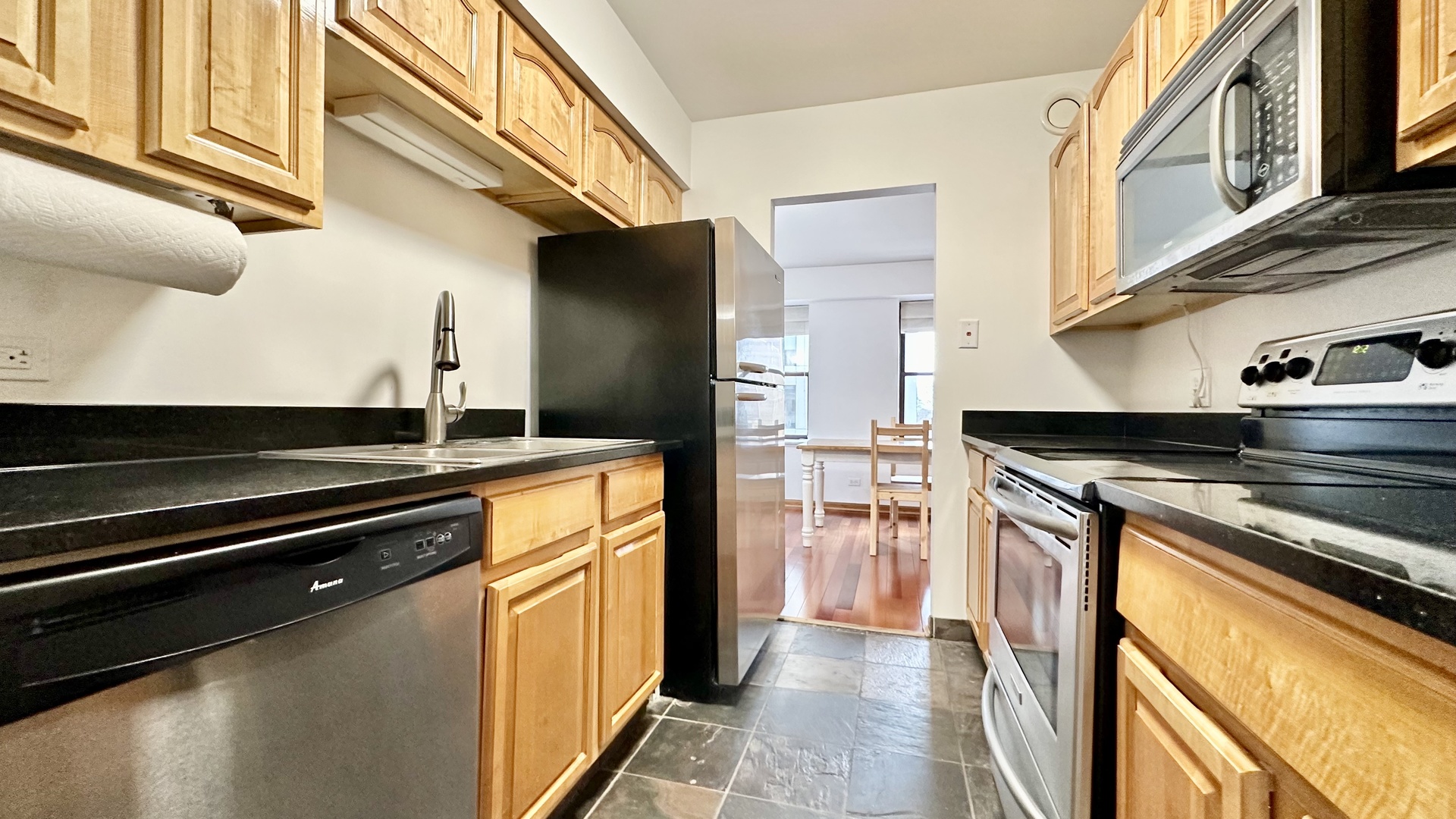 40 East 9th Street, Unit 402 Chicago, IL 60605 - Photo 11 of 24 a kitchen with stainless steel appliances granite countertop a stove and a refrigerator