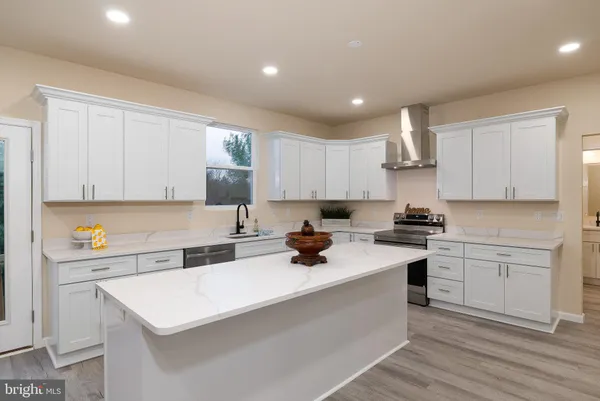 a kitchen with a sink a refrigerator and white cabinets