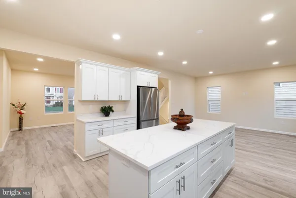 a kitchen with stainless steel appliances granite countertop a sink stove refrigerator and cabinets