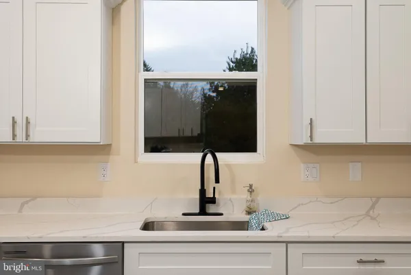 a view of kitchen with granite countertop cabinets and refrigerator
