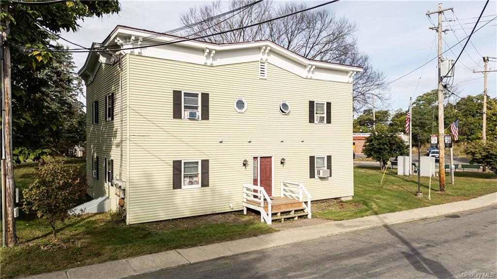 20 Church Street Claverack, NY 12534 - Photo 15 of 28 a view of a white house with a yard and lawn chairs under an umbrella