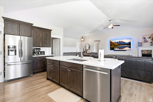 2973 West Red Sand Rd Haven Ogden, UT 84401 - Photo 11 of 30 Kitchen featuring a large island with white countertop, dark wood-finish cabinetry, stainless steel appliances, and wood-finish flooring
