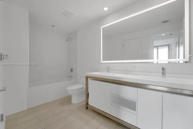 a bathroom with a granite countertop sink a toilet and a bathtub