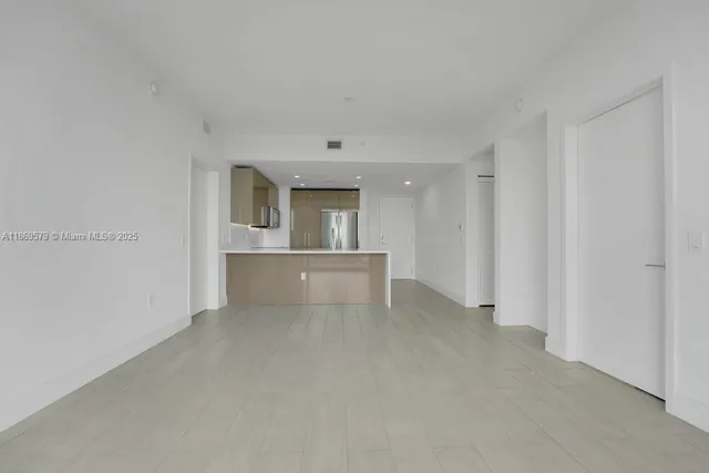 a view of a kitchen with a sink and a refrigerator