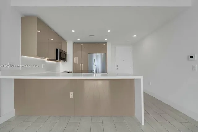 a large kitchen with kitchen island a sink dishwasher and a stove with wooden floor