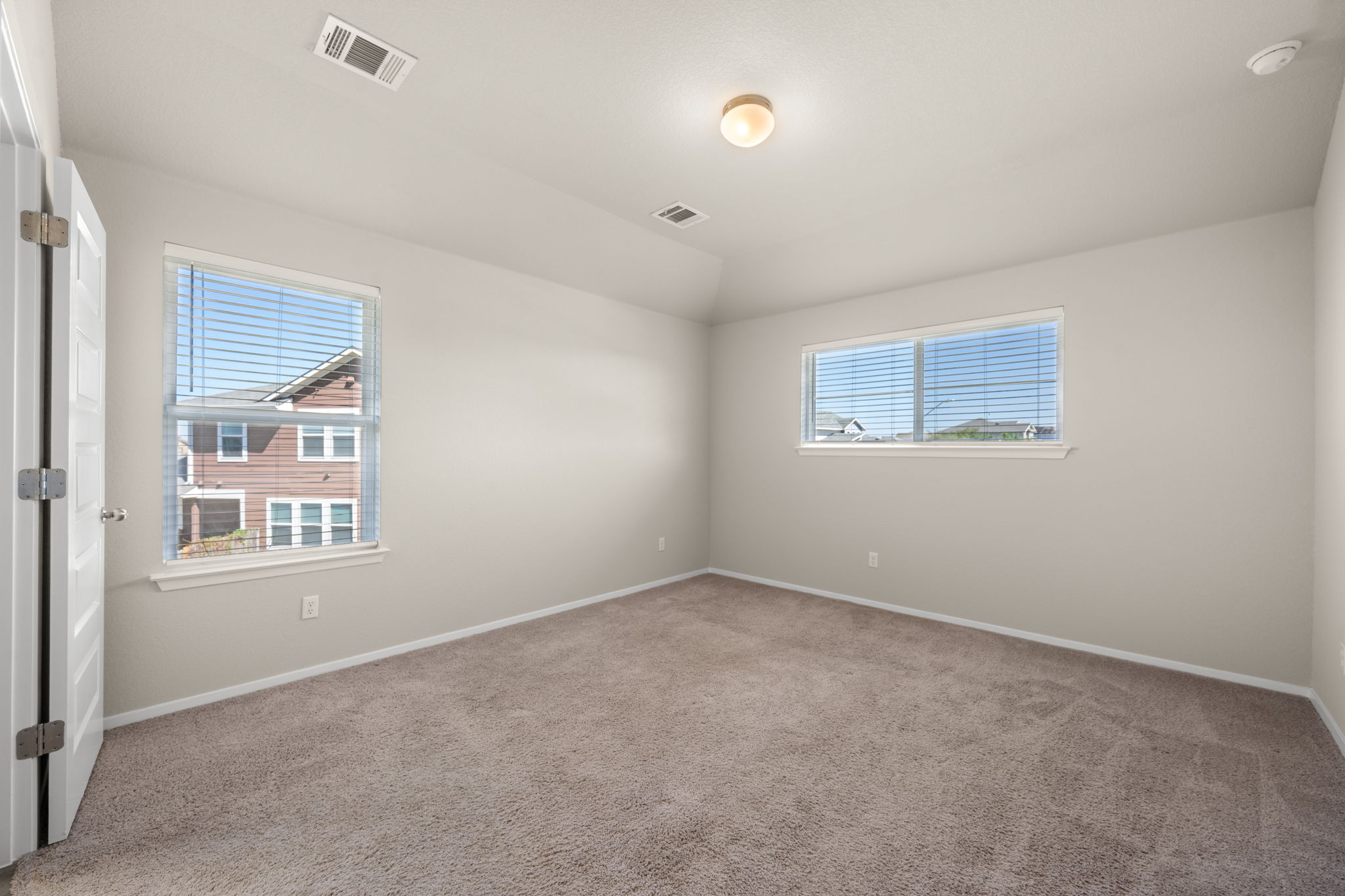215 Lake Placid Run Elgin, TX 78621 - Photo 14 of 29 Plush carpeting and tray ceilings frame this versatile bedroom space filled with natural light.