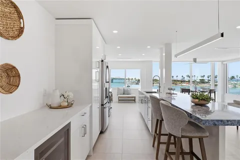 a kitchen with stainless steel appliances granite countertop a white stove top oven and couches