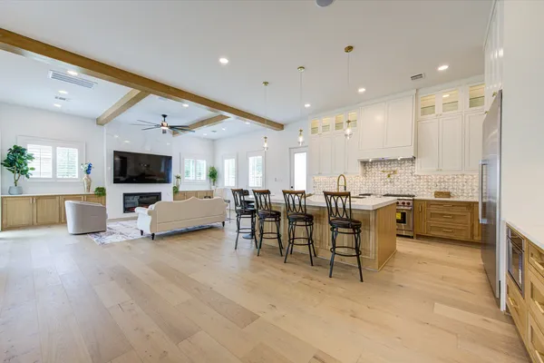 a kitchen with stainless steel appliances kitchen island granite countertop a sink a stove a dining table and chairs