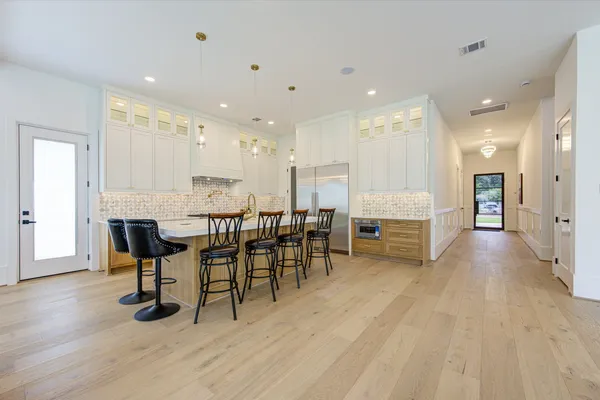 a large kitchen with stainless steel appliances granite countertop a lot of counter space and wooden floor