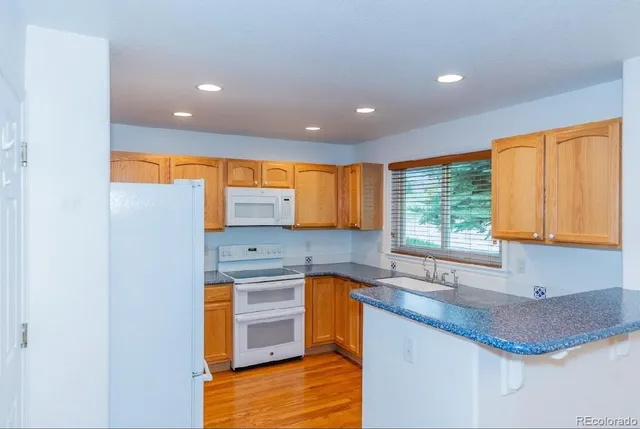 a kitchen with stainless steel appliances granite countertop a sink a stove and a refrigerator