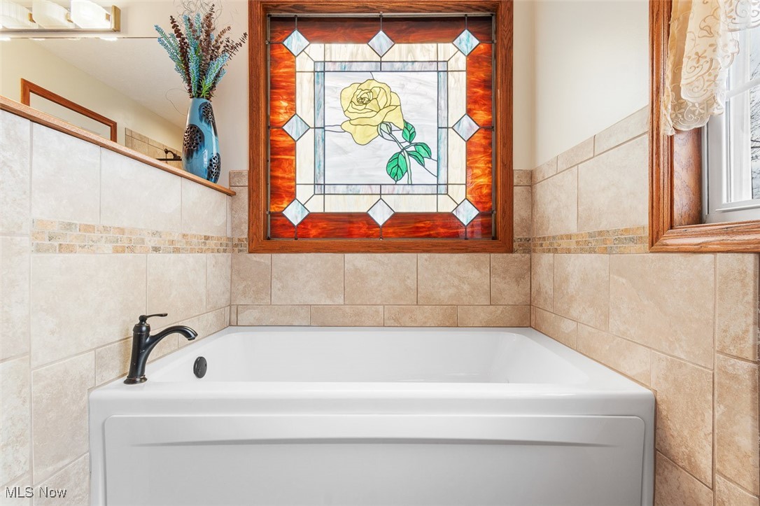 2271 Graybill Road Uniontown, OH 44685 - Photo 20 of 44 Bathroom with tile walls and a garden tub