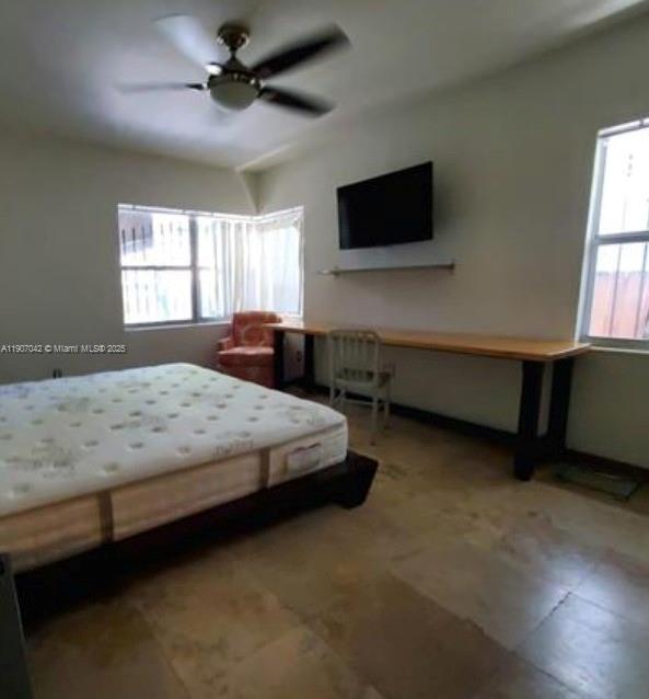 6918 Northeast 5th Avenue Miami, FL 33138 - Photo 4 of 9 a spacious bedroom with a bed and a flat screen tv