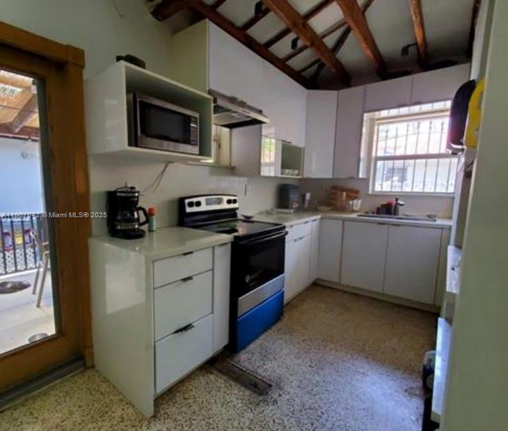 6918 Northeast 5th Avenue Miami, FL 33138 - Photo 6 of 9 a kitchen with stainless steel appliances granite countertop a sink a stove top oven a chimney and a window