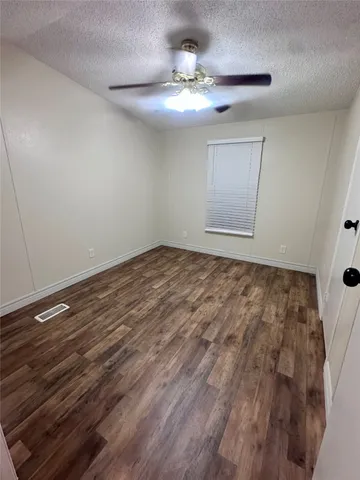 a view of an empty room with a chandelier fan