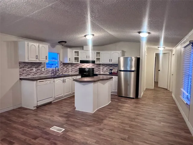 a kitchen with stainless steel appliances a refrigerator sink and cabinets