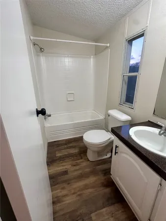a bathroom with a sink a toilet a mirror and shower