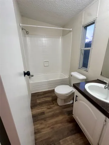 a bathroom with a sink a toilet a mirror and shower
