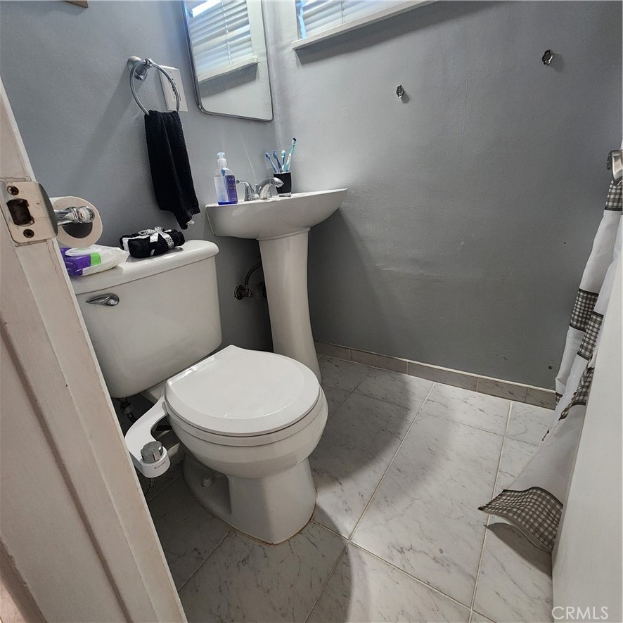 3076 Ronald Street Riverside, CA 92506 - Photo 16 of 17 a white toilet sitting next to a bathroom sink