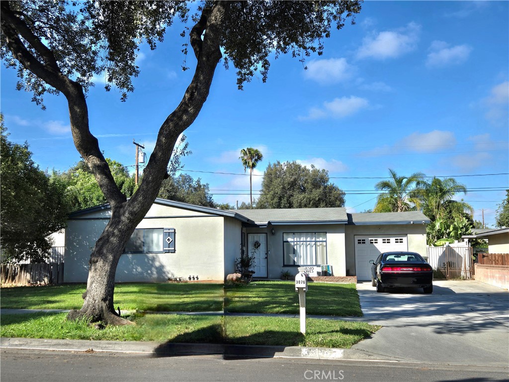 3076 Ronald Street Riverside, CA 92506 - Photo 2 of 19 a front view of a house with a garden and trees