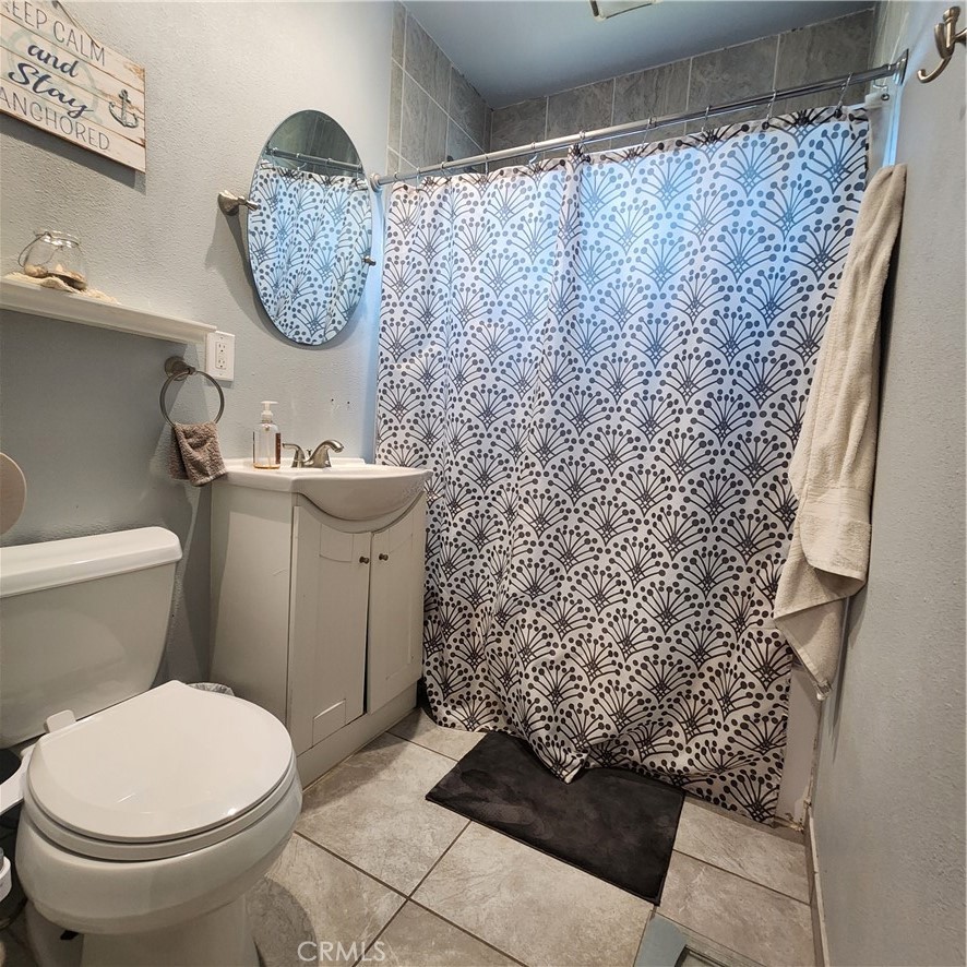 3076 Ronald Street Riverside, CA 92506 - Photo 6 of 17 a bathroom with a toilet and a shower curtain