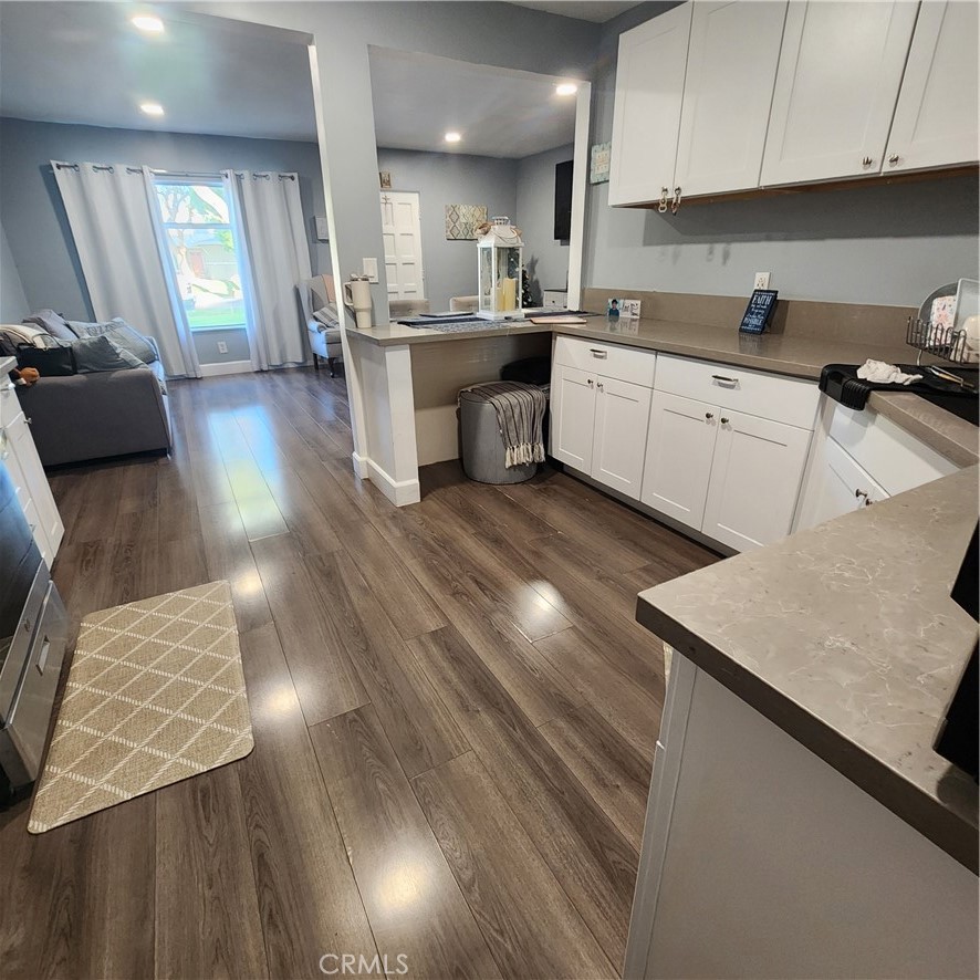 3076 Ronald Street Riverside, CA 92506 - Photo 8 of 19 a kitchen with a sink dishwasher a stove a dining table and chairs with wooden floor