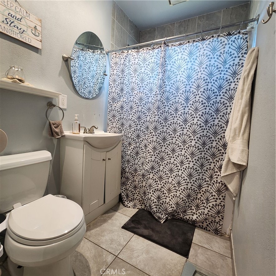 3076 Ronald Street Riverside, CA 92506 - Photo 9 of 19 a bathroom with a toilet and a shower curtain
