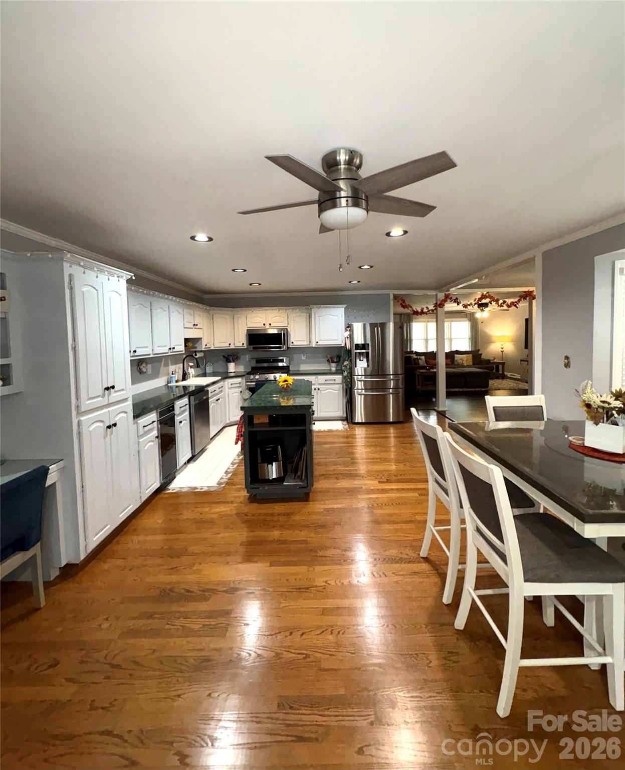 109 Churchill Road Dallas, NC 28034 - Photo 8 of 40 a kitchen with stainless steel appliances granite countertop a stove top oven a refrigerator a dining table and chairs with wooden floor