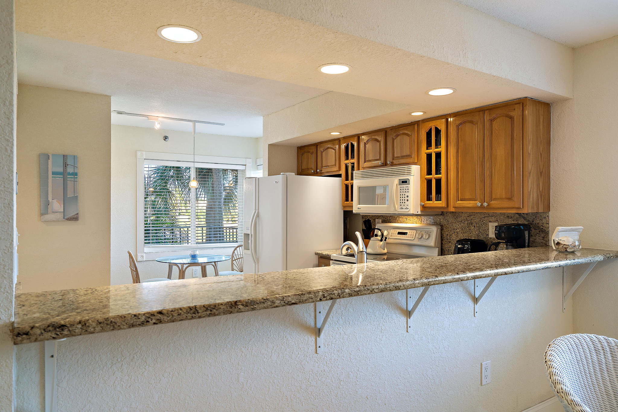 275 Palm Avenue, Unit C201 Jupiter, FL 33477 - Photo 12 of 24 a large kitchen with granite countertop a sink and a refrigerator