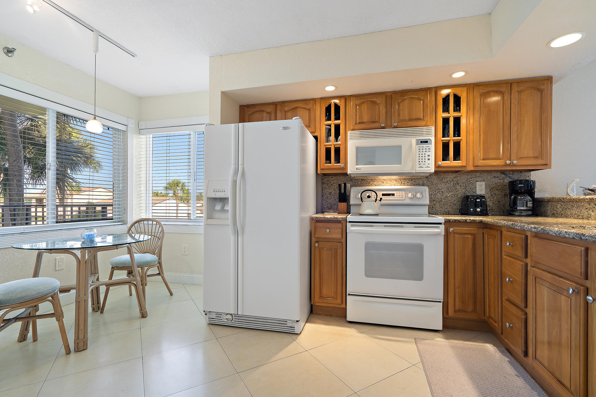 275 Palm Avenue, Unit C201 Jupiter, FL 33477 - Photo 18 of 24 a kitchen with a refrigerator a stove a dining table and chairs