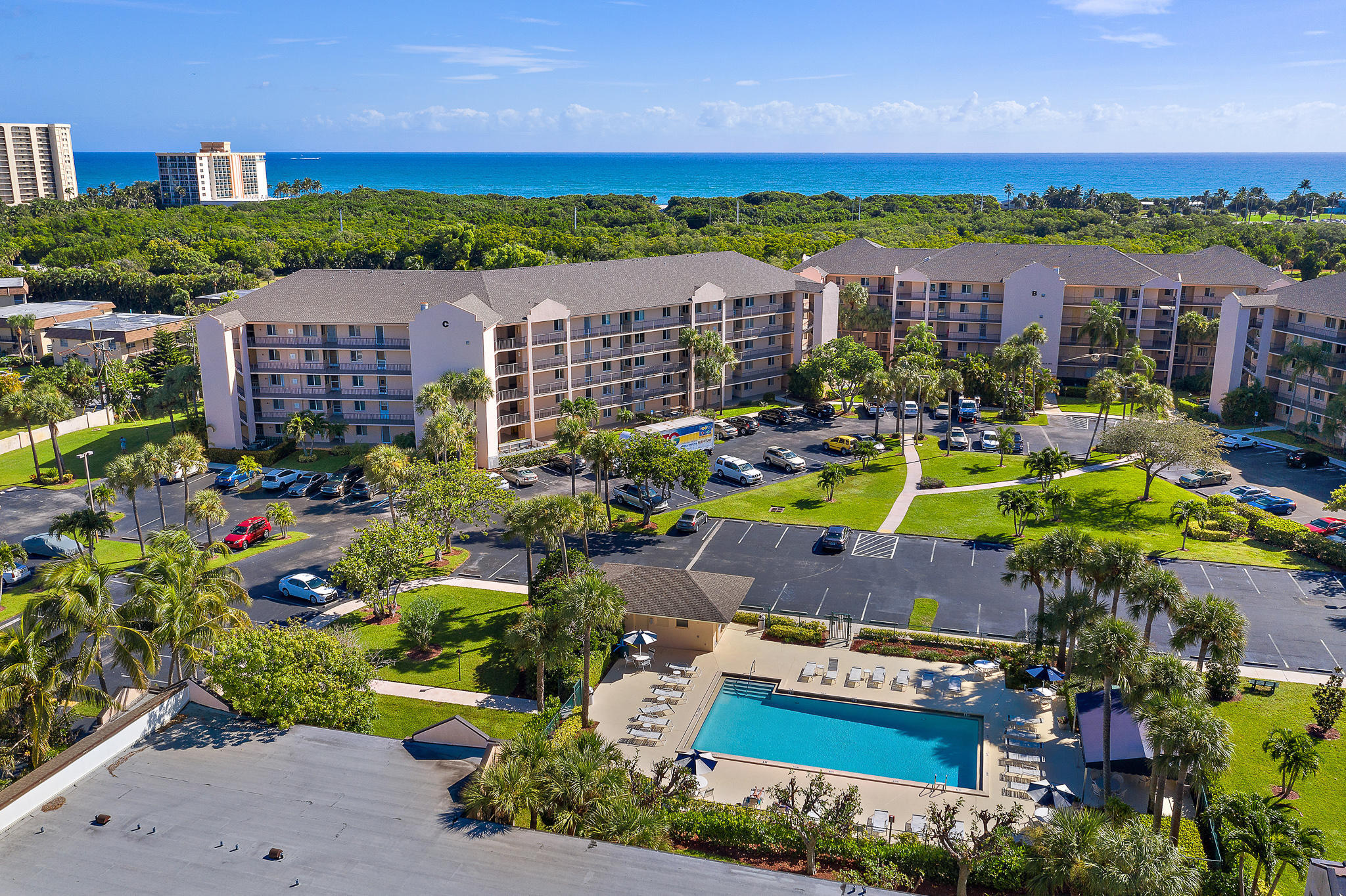 275 Palm Avenue, Unit C201 Jupiter, FL 33477 - Photo 2 of 24 a view of swimming pool with outdoor seating and yard in the back