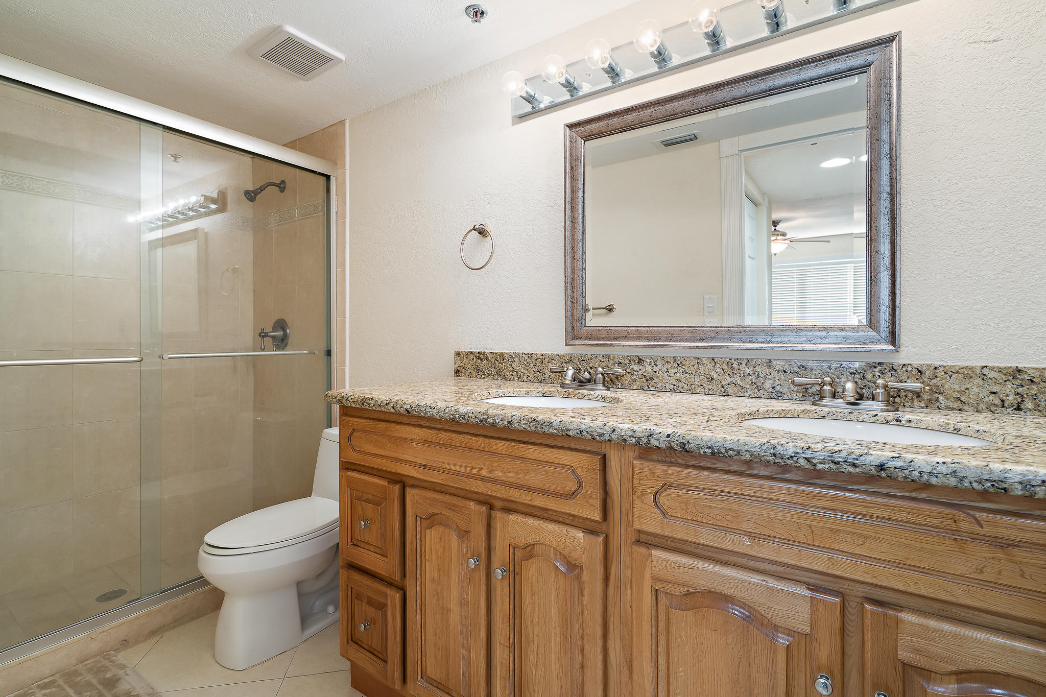 275 Palm Avenue, Unit C201 Jupiter, FL 33477 - Photo 9 of 24 a bathroom with a granite countertop sink toilet a mirror and shower