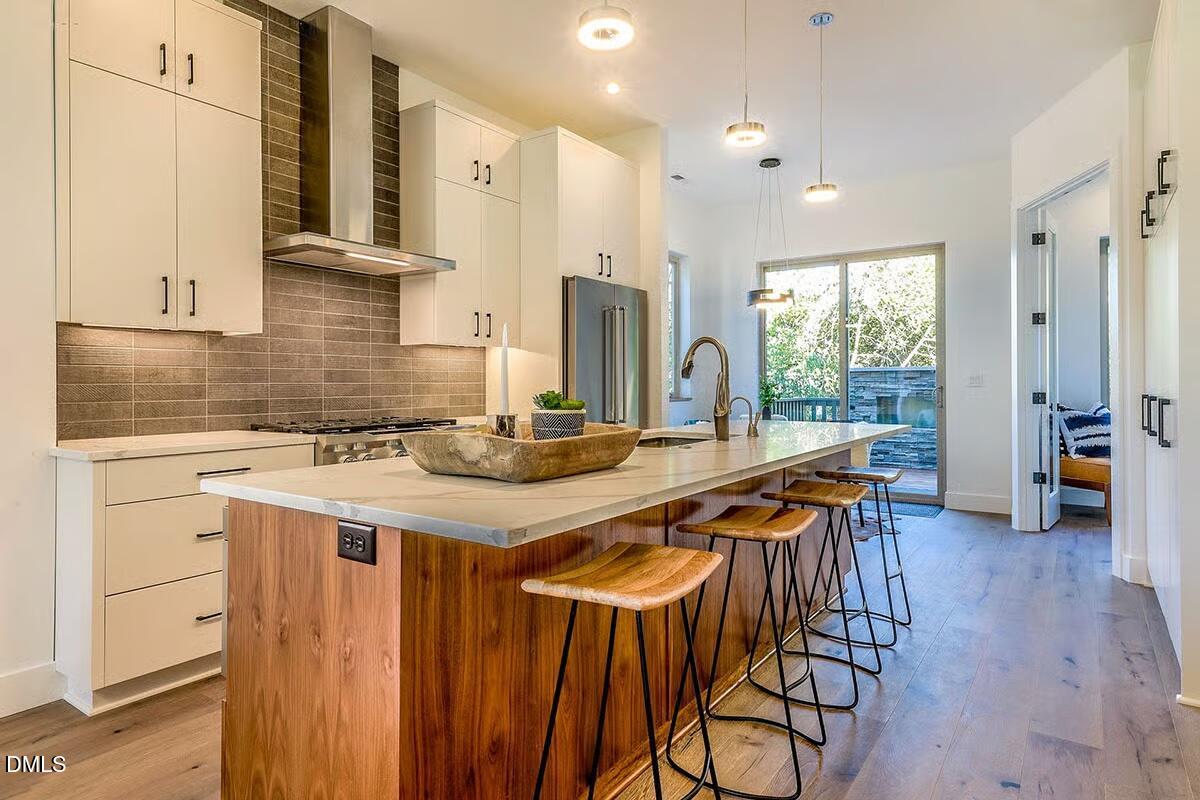 804 Cotton Place, Unit 102 Raleigh, NC 27601 - Photo 4 of 15 a kitchen with stainless steel appliances a table and chairs