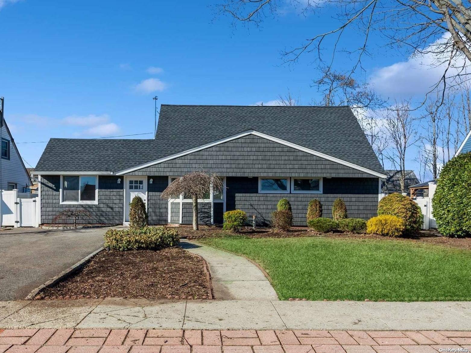 a front view of a house with a yard and trees