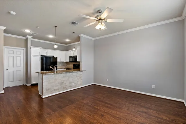 a view of a livingroom with furniture wooden floor and a ceiling fan