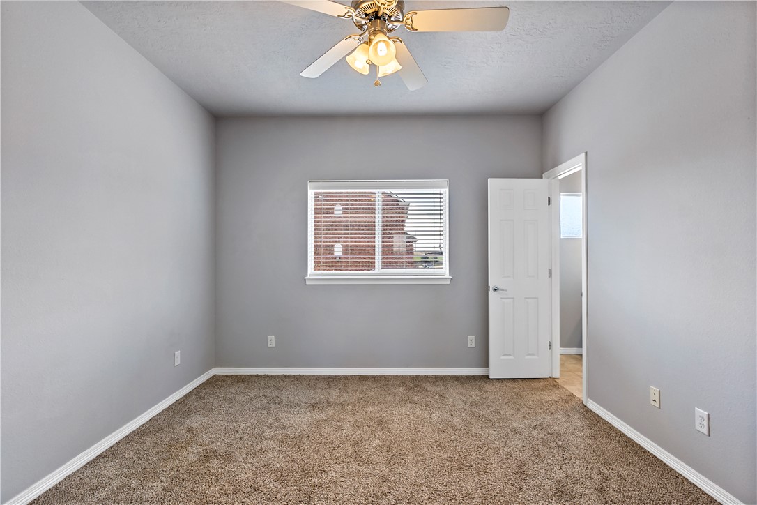 1198 Jones-Butler Road, Unit 1402 College Station, TX 77840 - Photo 12 of 20 an empty room with windows and chandelier fan