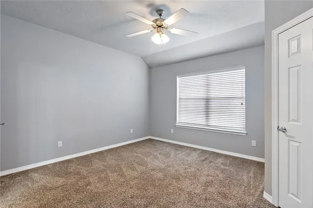 an empty room with windows and ceiling fan