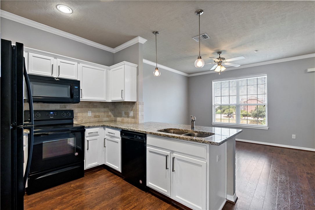 1198 Jones-Butler Road, Unit 1402 College Station, TX 77840 - Photo 4 of 20 a kitchen with stainless steel appliances granite countertop a sink stove and microwave