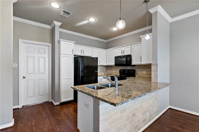 a kitchen with kitchen island granite countertop stainless steel appliances and wooden cabinets
