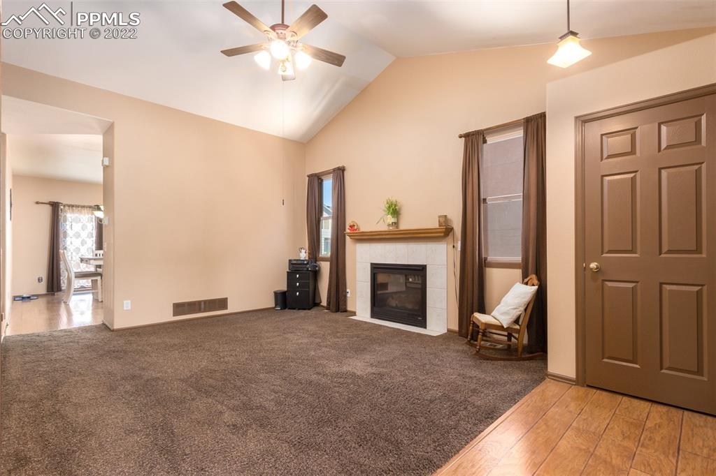 7542 Stephenville Road Peyton, CO 80831 - Photo 6 of 32 a view of a livingroom with a fireplace a chandelier and windows
