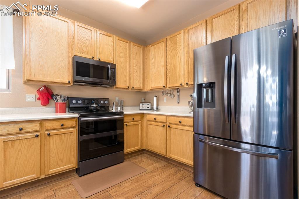 7542 Stephenville Road Peyton, CO 80831 - Photo 9 of 32 a kitchen with stainless steel appliances a refrigerator sink and microwave