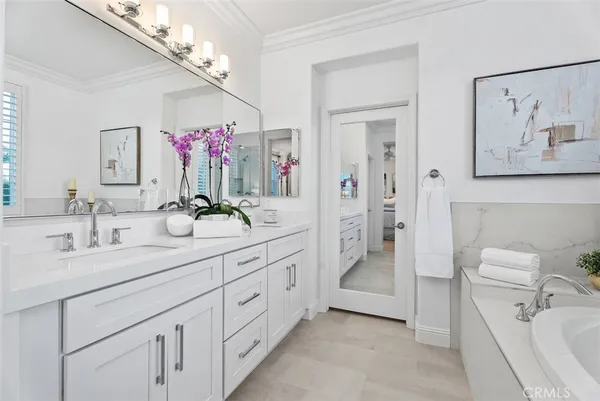 a spacious bathroom with a double vanity sink a mirror a bathtub and a shower