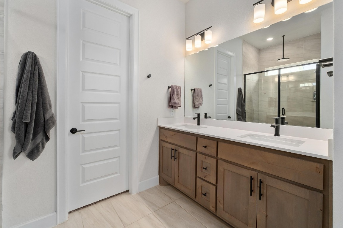 4513 Sea Salt Drive Austin, TX 78747 - Photo 15 of 31 a bathroom with a double vanity sink and mirror