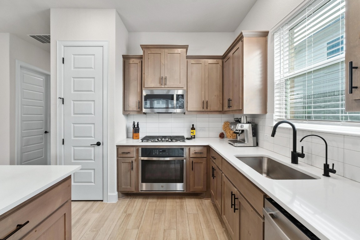 4513 Sea Salt Drive Austin, TX 78747 - Photo 8 of 31 a kitchen with stainless steel appliances granite countertop a sink stove and refrigerator