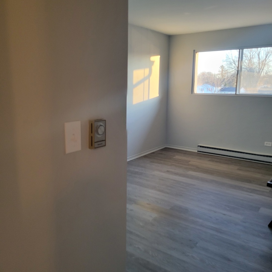 850 East Old Willow Road, Unit 218 Prospect Heights, IL 60070 - Photo 9 of 11 an empty room with wooden floor and windows