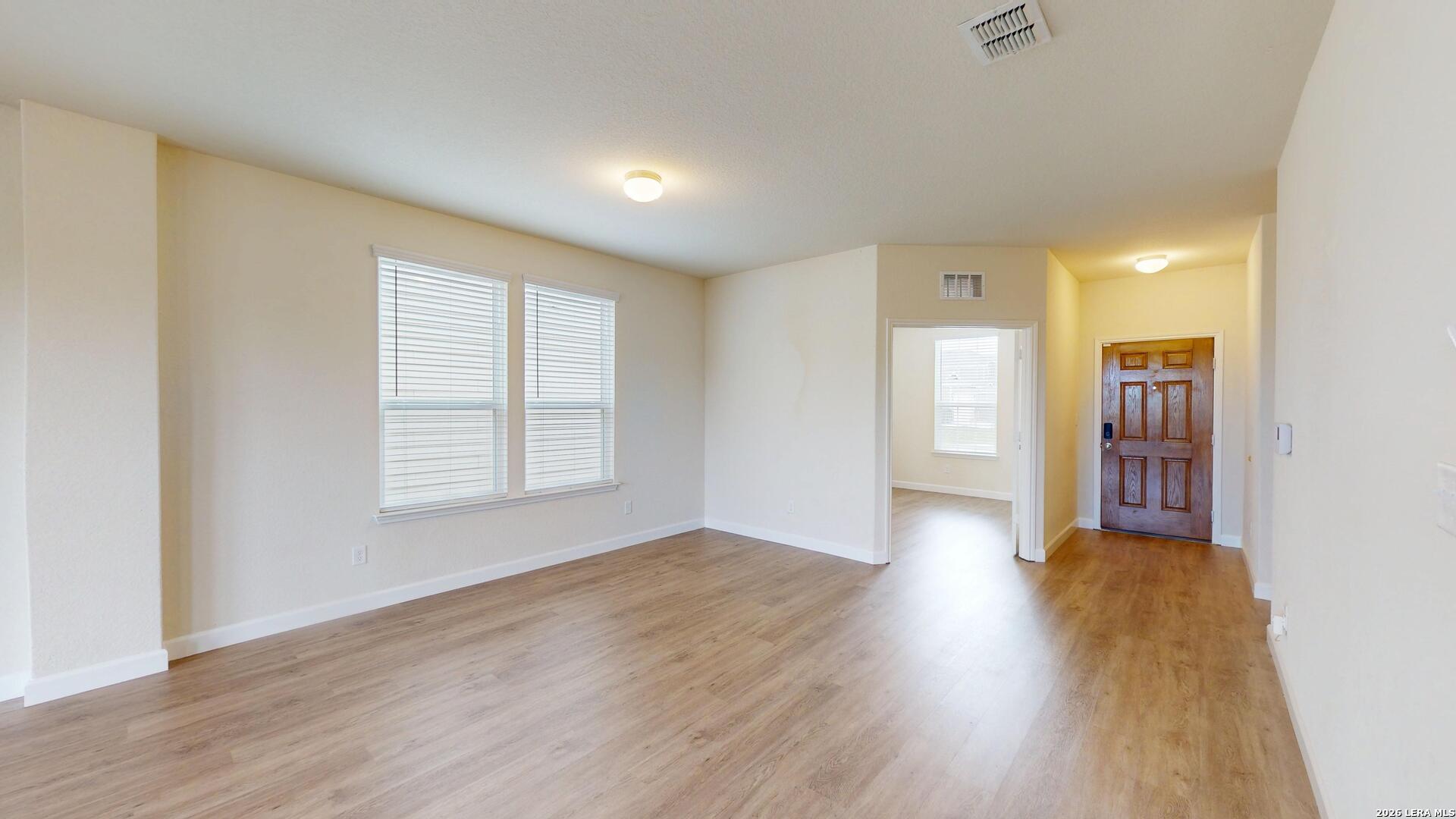 344 Autumn Rouge New Braunfels, TX 78130 - Photo 4 of 16 an empty room with wooden floor and windows