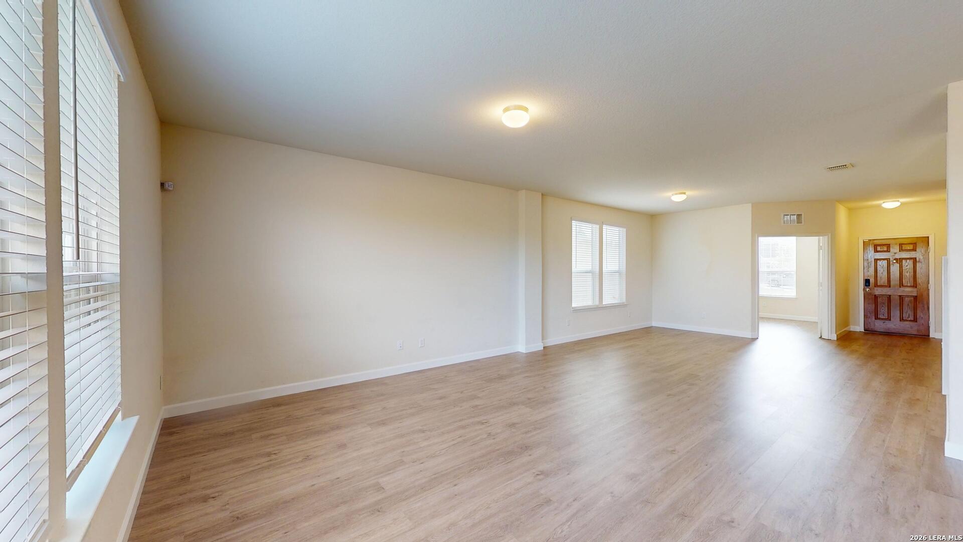 344 Autumn Rouge New Braunfels, TX 78130 - Photo 8 of 16 an empty room with wooden floor and windows