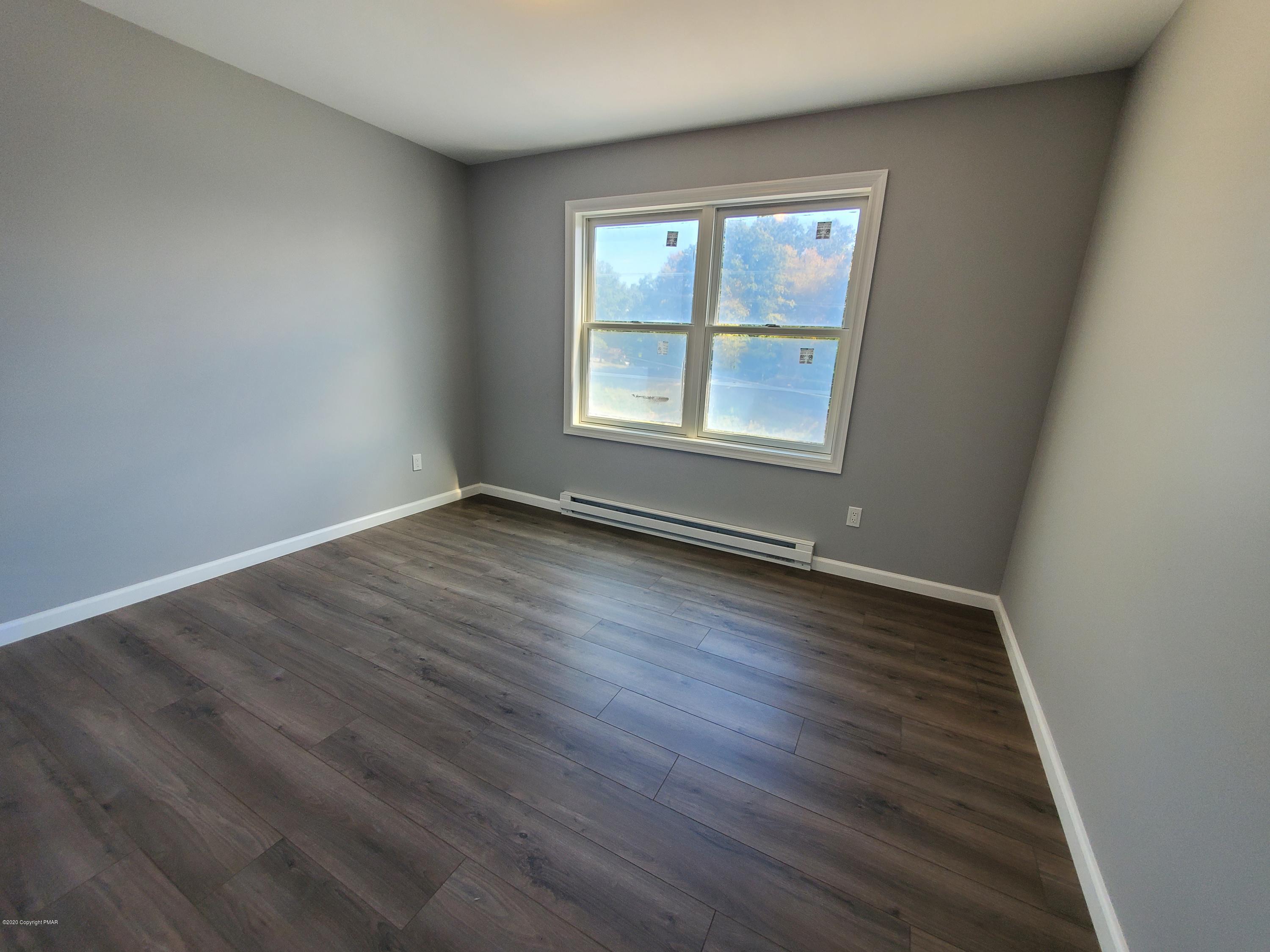 2273 Milford Road Bushkill, PA 18324 - Photo 7 of 23 an empty room with wooden floor and windows
