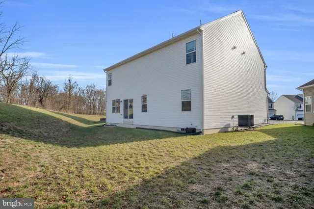 a view of a house with backyard and trees