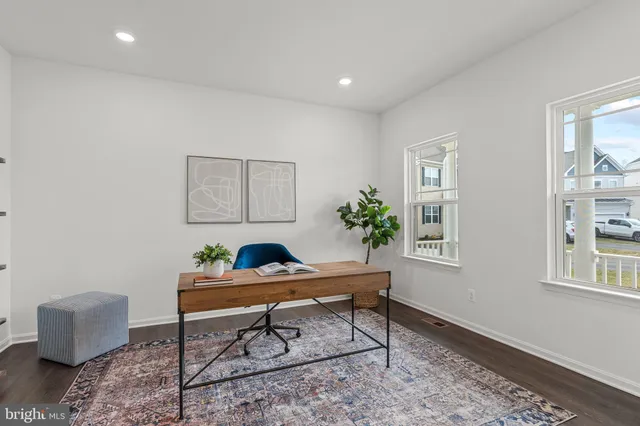 a workspace room with furniture and a potted plant