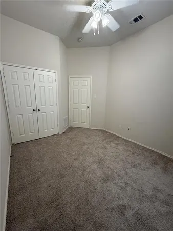 an empty room with a chandelier fan